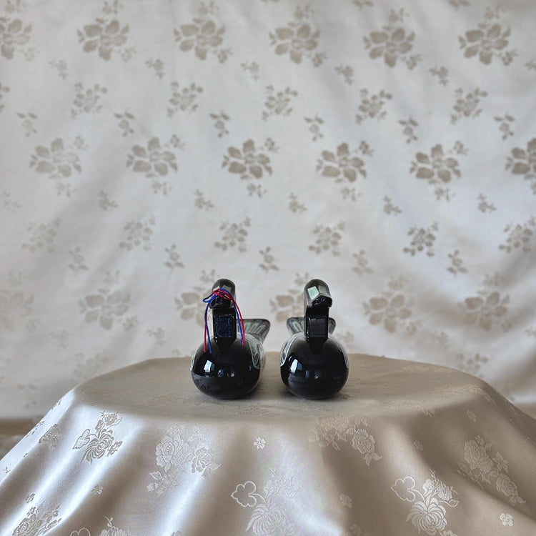 Front view of a large Korean mother-of-pearl wedding duck pair in black lacquer