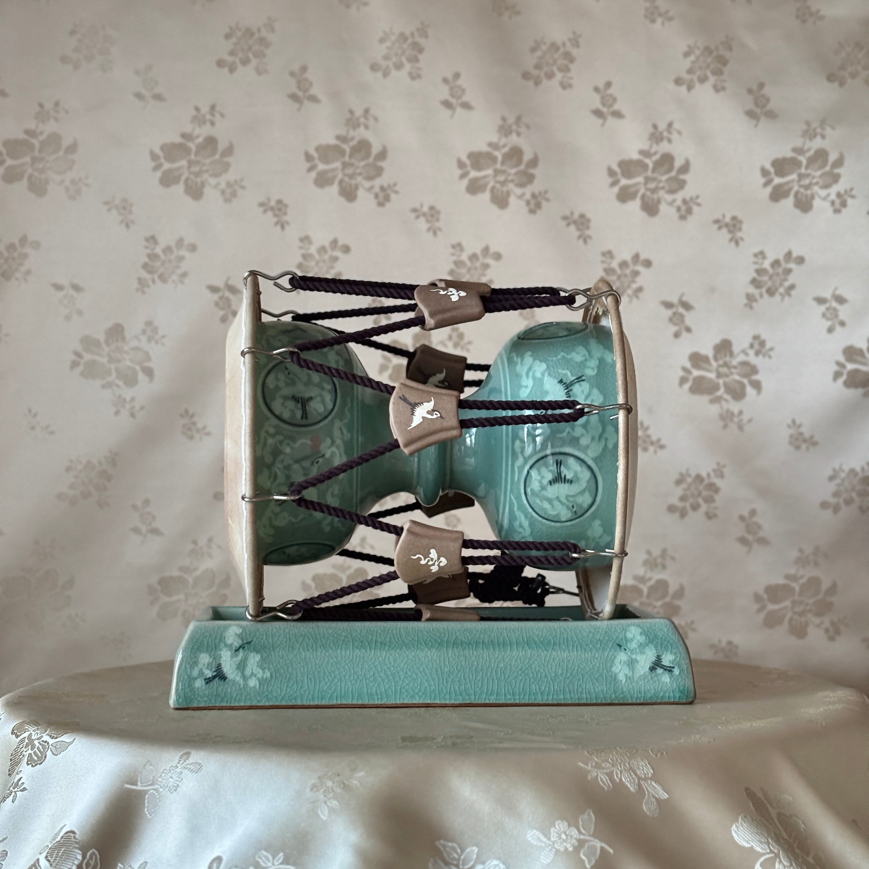 Decorative item with teal and silver design on a floral-patterned background Korean traditional
