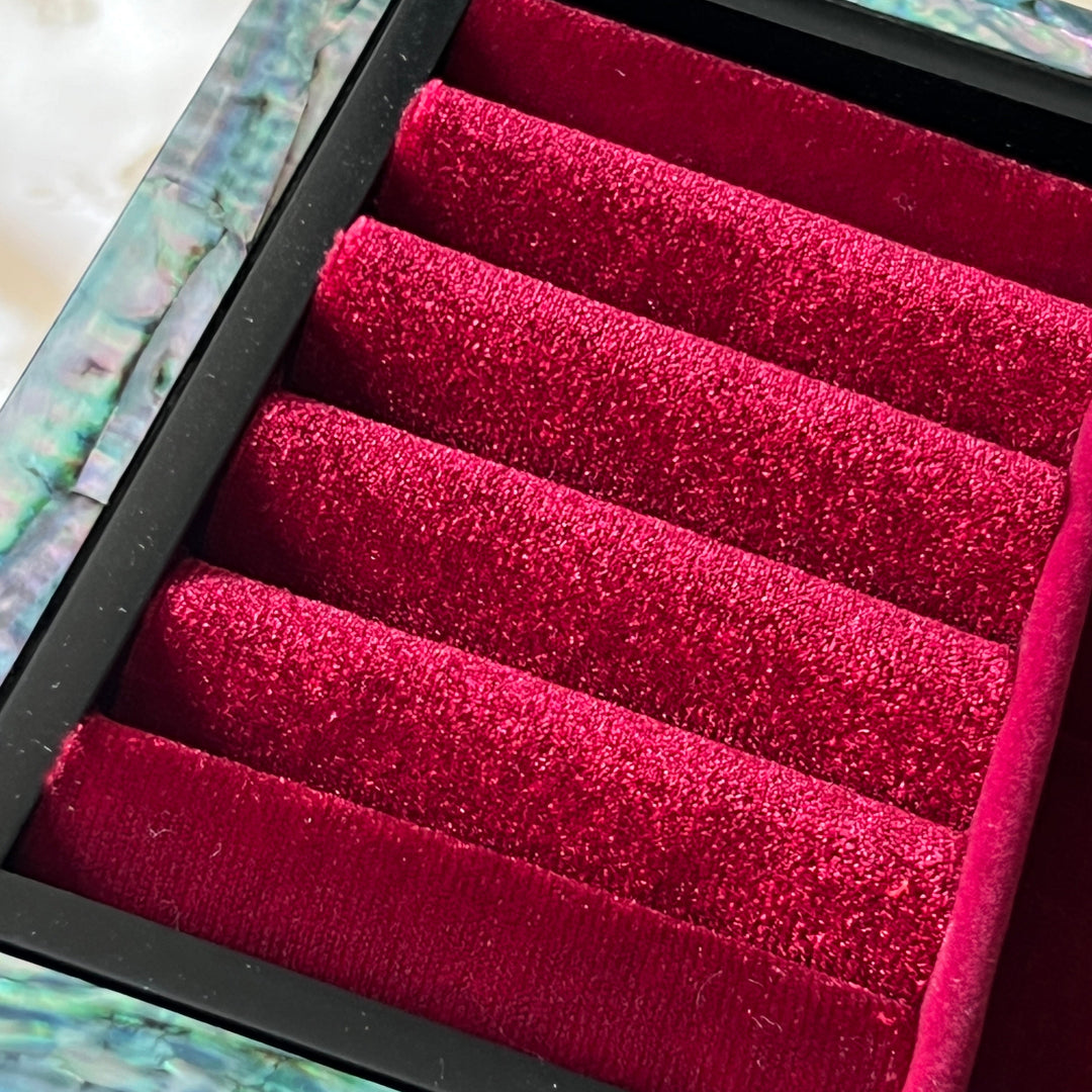 Close-up of red velvet ring rolls inside a Korean mother-of-pearl jewelry box