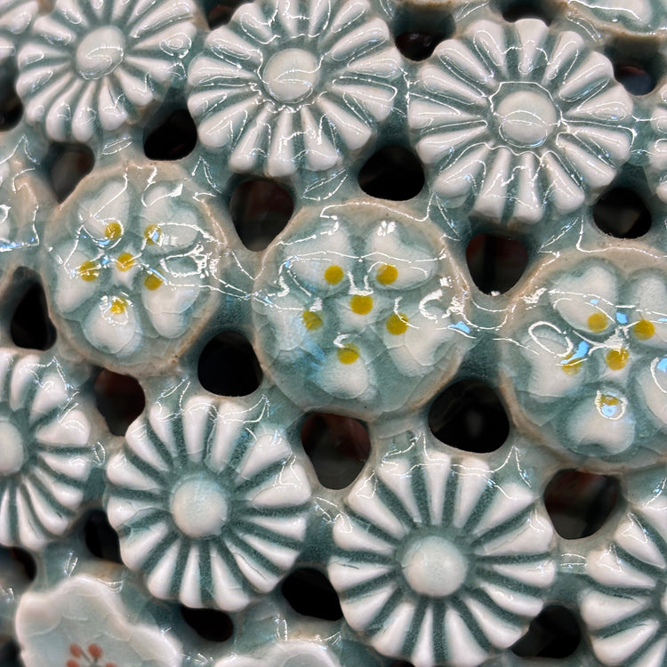 Close-up of celadon vase with floral patterns