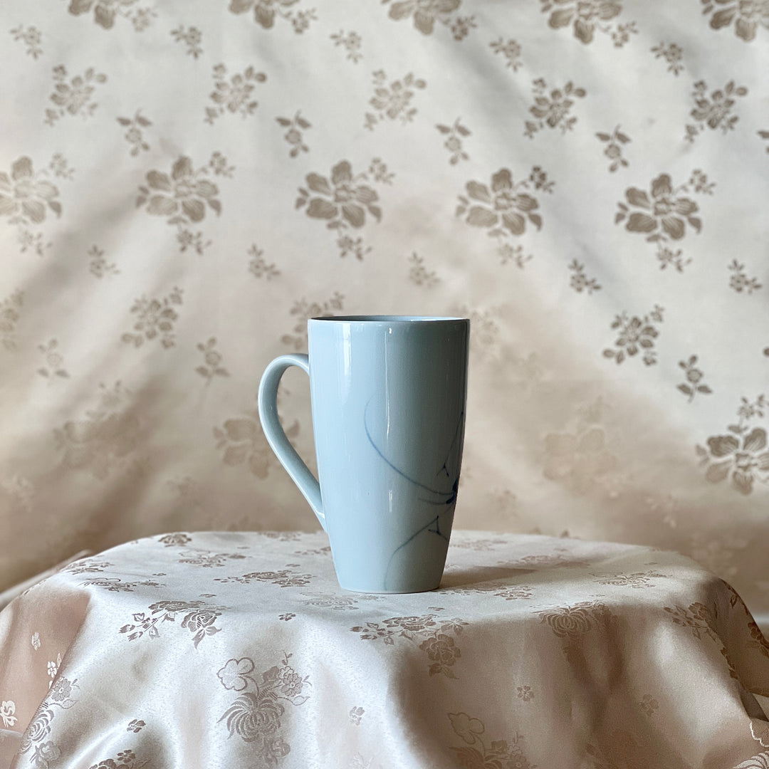 Back view of a Korean white porcelain mug showing the plain white porcelain body and handle
