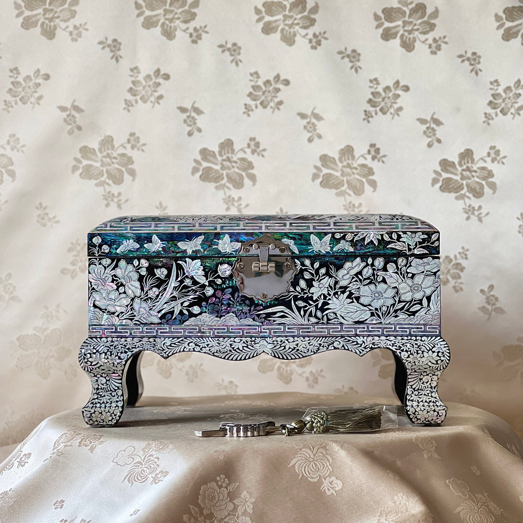 Front view of a Korean mother-of-pearl legged jewelry box with metal clasp and raised decorative legs