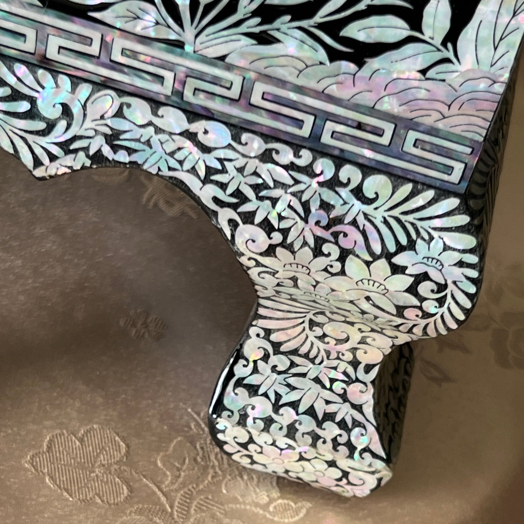Close-up of a raised decorative leg on a Korean mother-of-pearl jewelry box with black lacquer finish