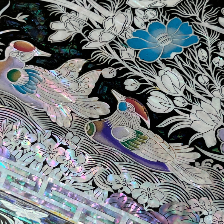 Detailed view of mandarin duck, flower, and butterfly mother-of-pearl inlay on a Korean jewelry box