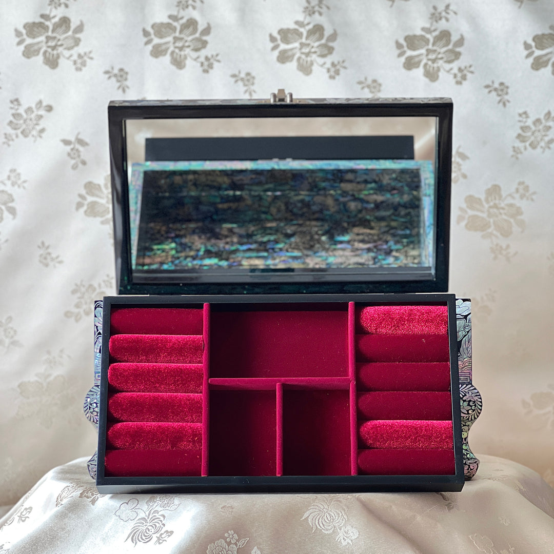 Interior view of a Korean mother-of-pearl jewelry box with red velvet ring rolls and storage compartments