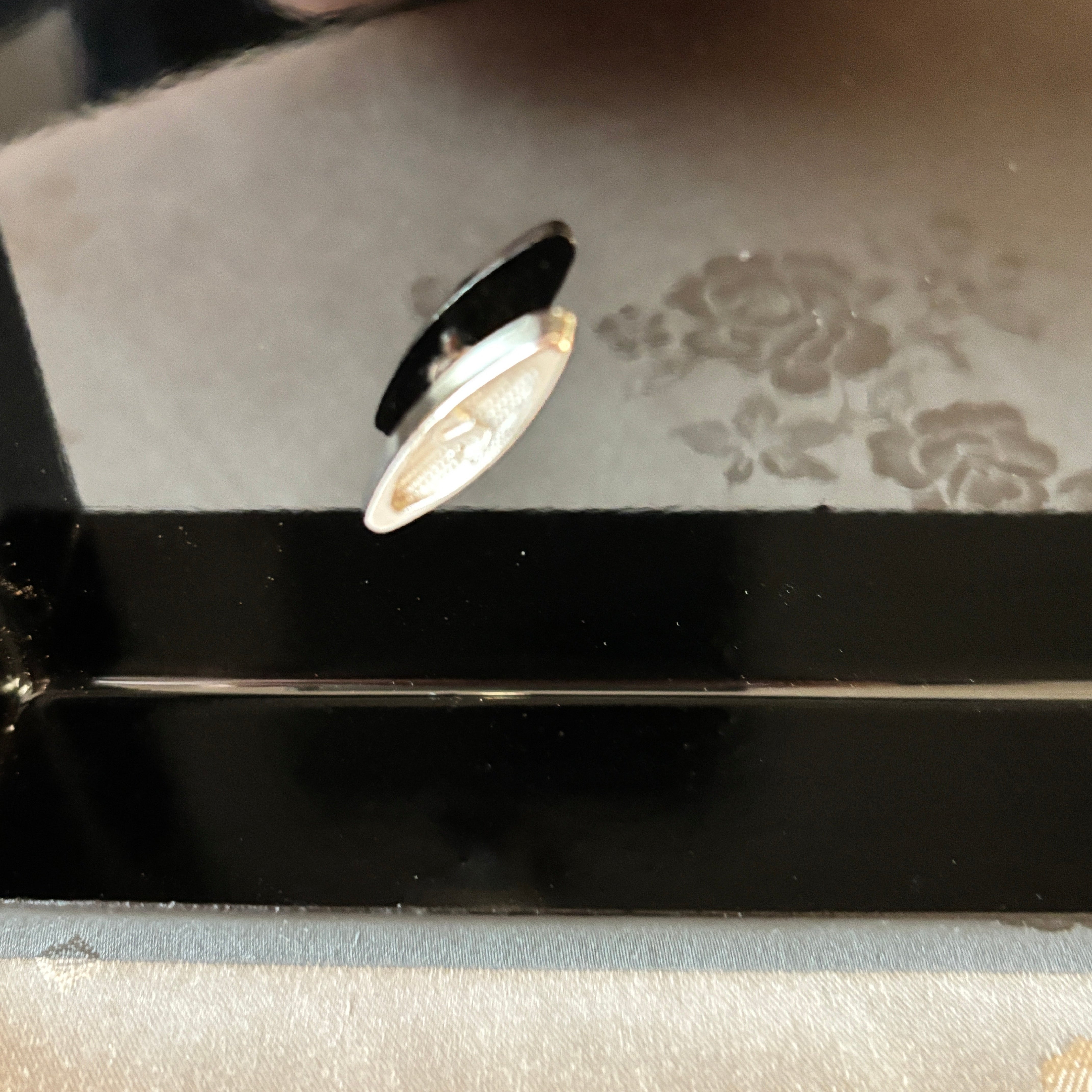 Close-up of a decorative switch in music box with floral patterns.