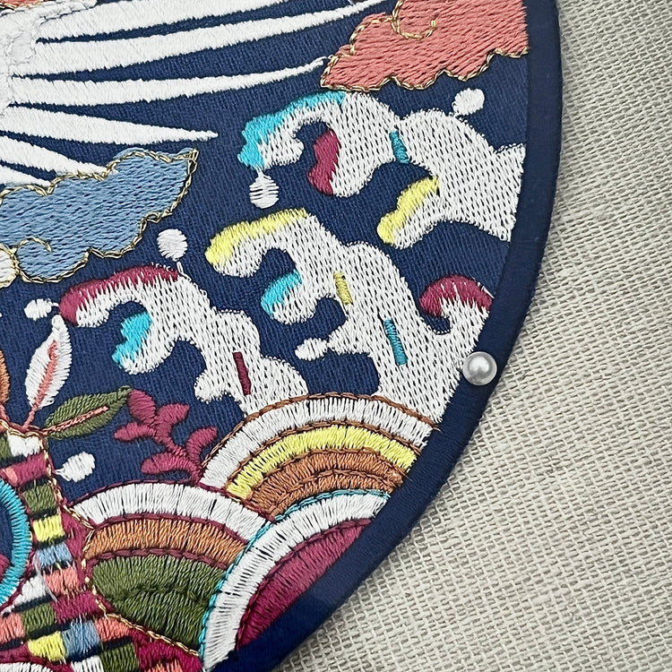 Embroidered patch with colorful wave design on a textured fabric background