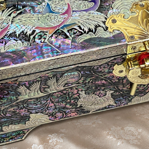 Close-up of the front panel with crane and turtle inlay and the gold latch