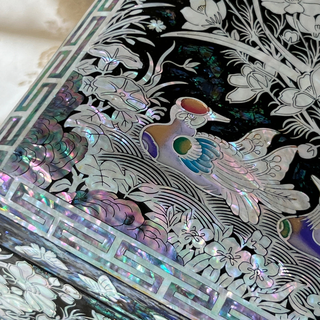 Close-up of a colored mandarin duck motif in mother-of-pearl inlay on black lacquer