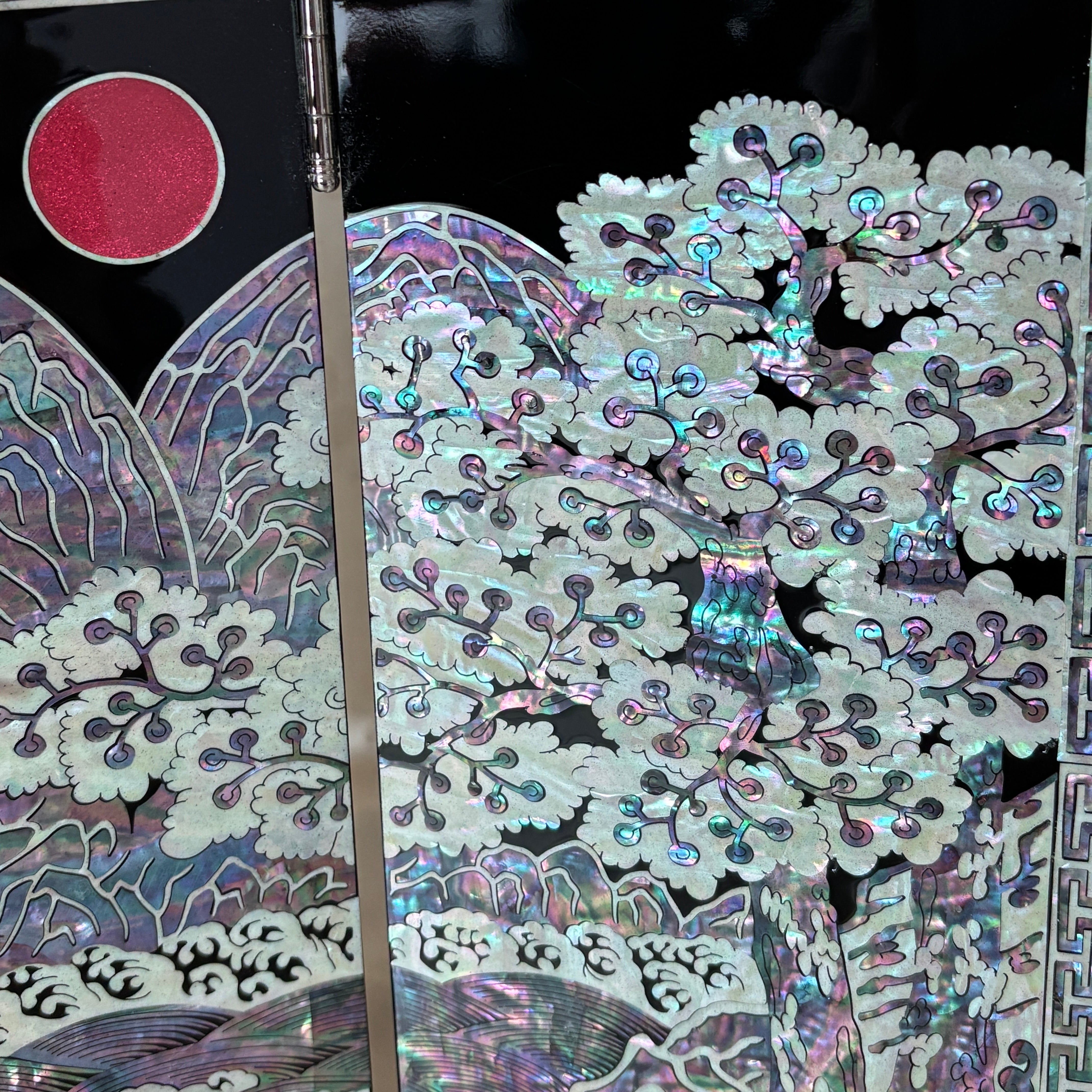 Close-up of a decorative item with intricate patterns and a brush on a black background
