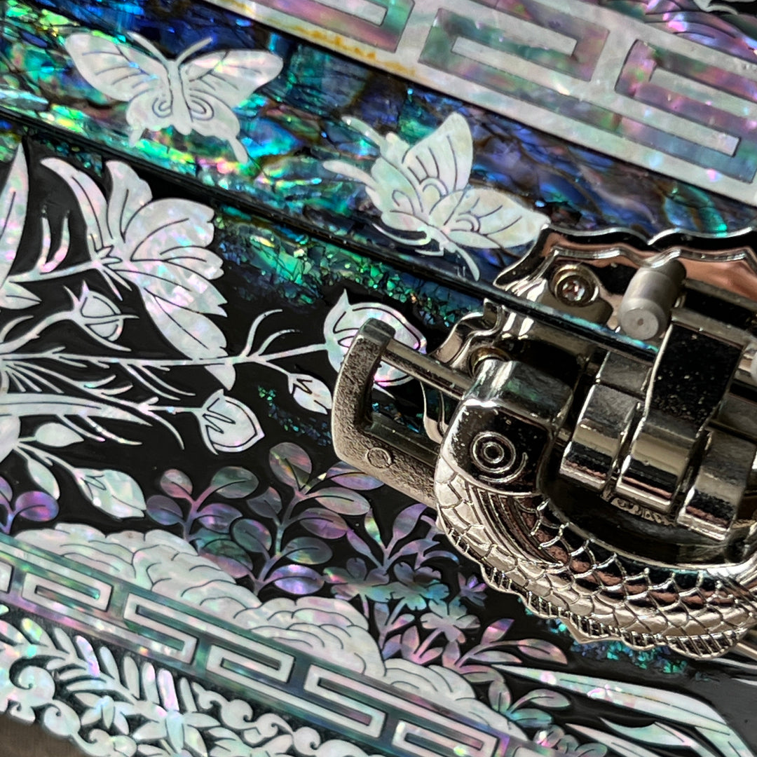 Close-up of the metal clasp on a Korean mother-of-pearl jewelry box with iridescent shell inlay