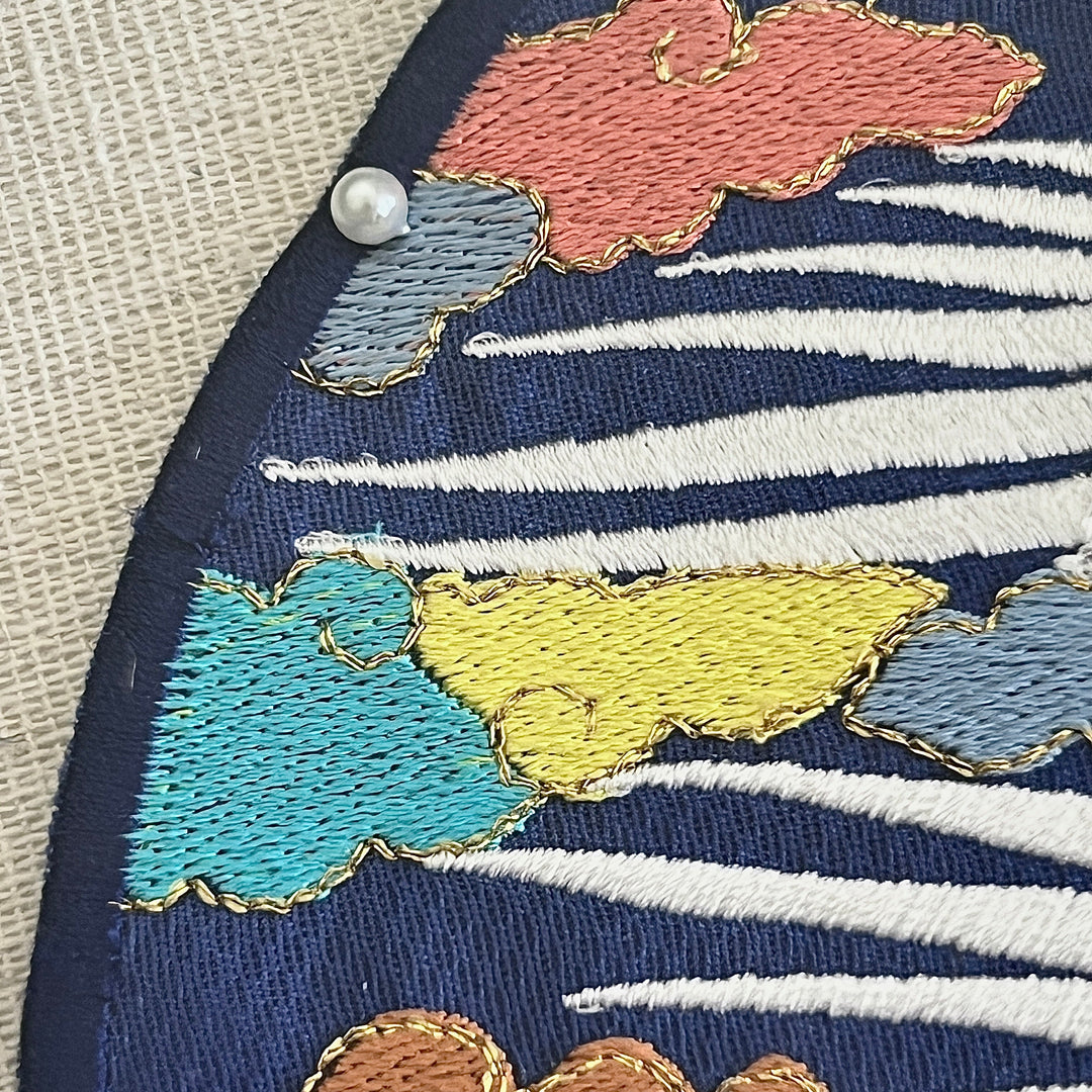Embroidered fabric with colorful cloud patterns on a blue background