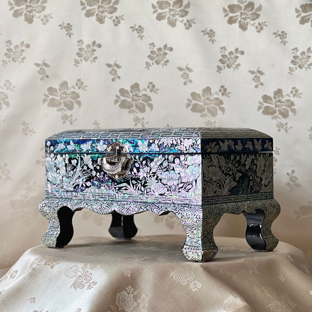 Side view of a Korean mother-of-pearl legged jewelry box with floral shell inlay and raised legs