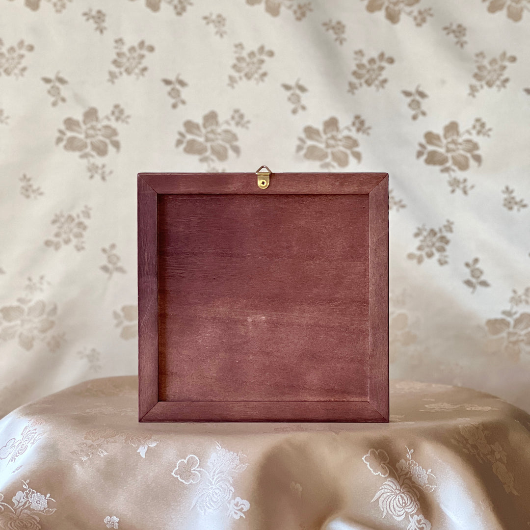 Wooden frame on a floral-patterned surface