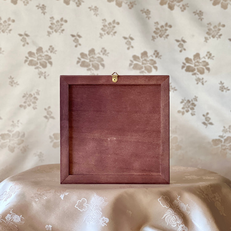 Wooden frame on a floral-patterned surface