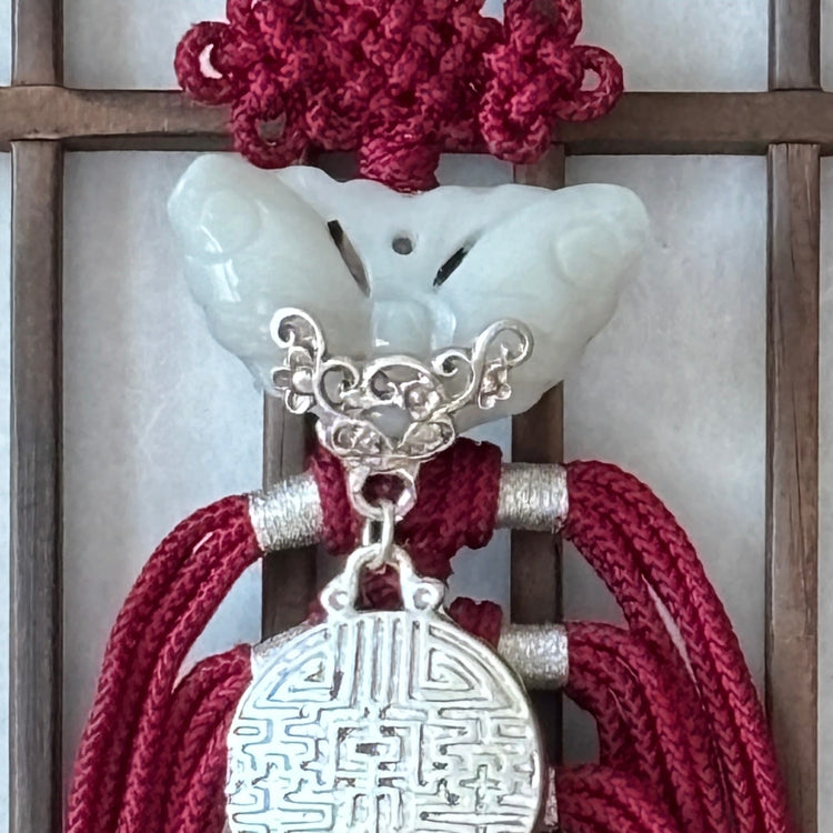 Decorative red tassels with silver embellishments on a wooden lattice background