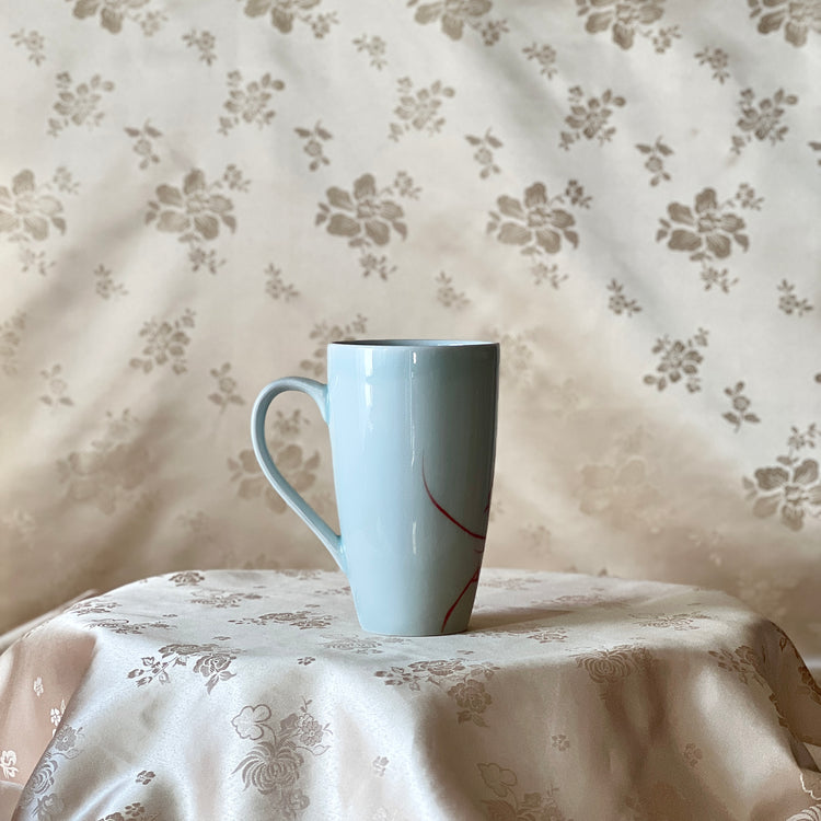Back view of a Korean white porcelain mug showing the plain white surface and handle