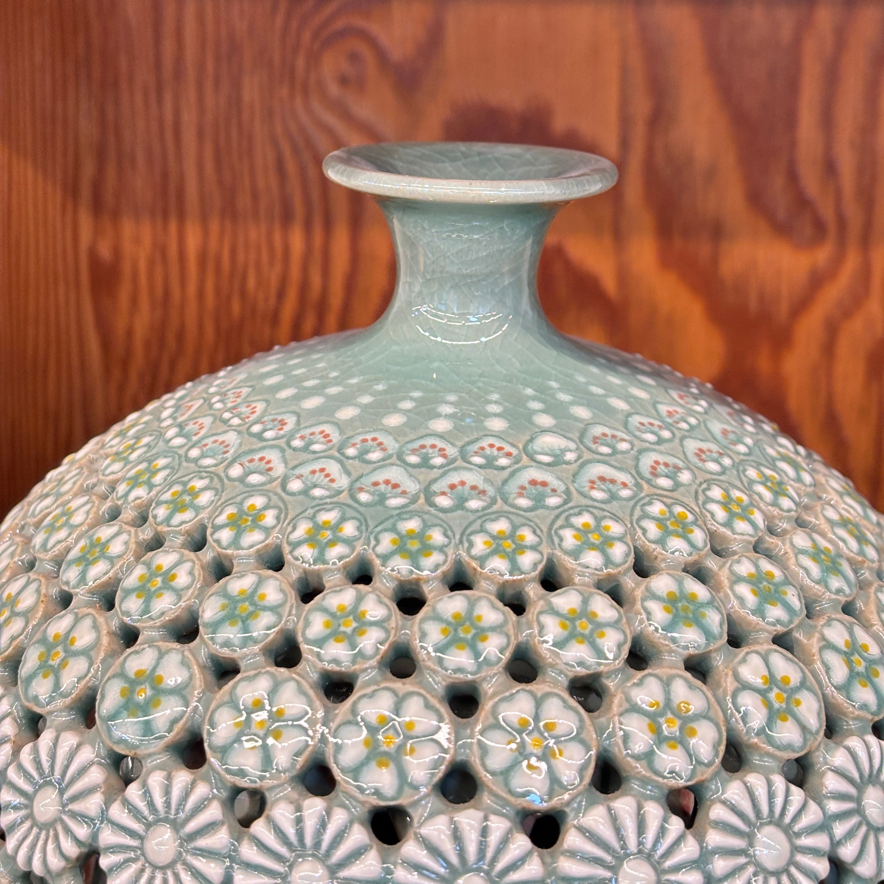 Decorative ceramic vase with floral patterns on a wooden surface