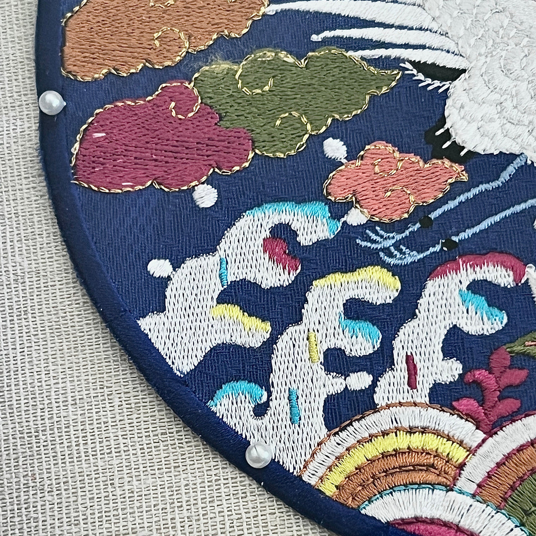 Embroidered patch with colorful clouds and wave design on a blue background