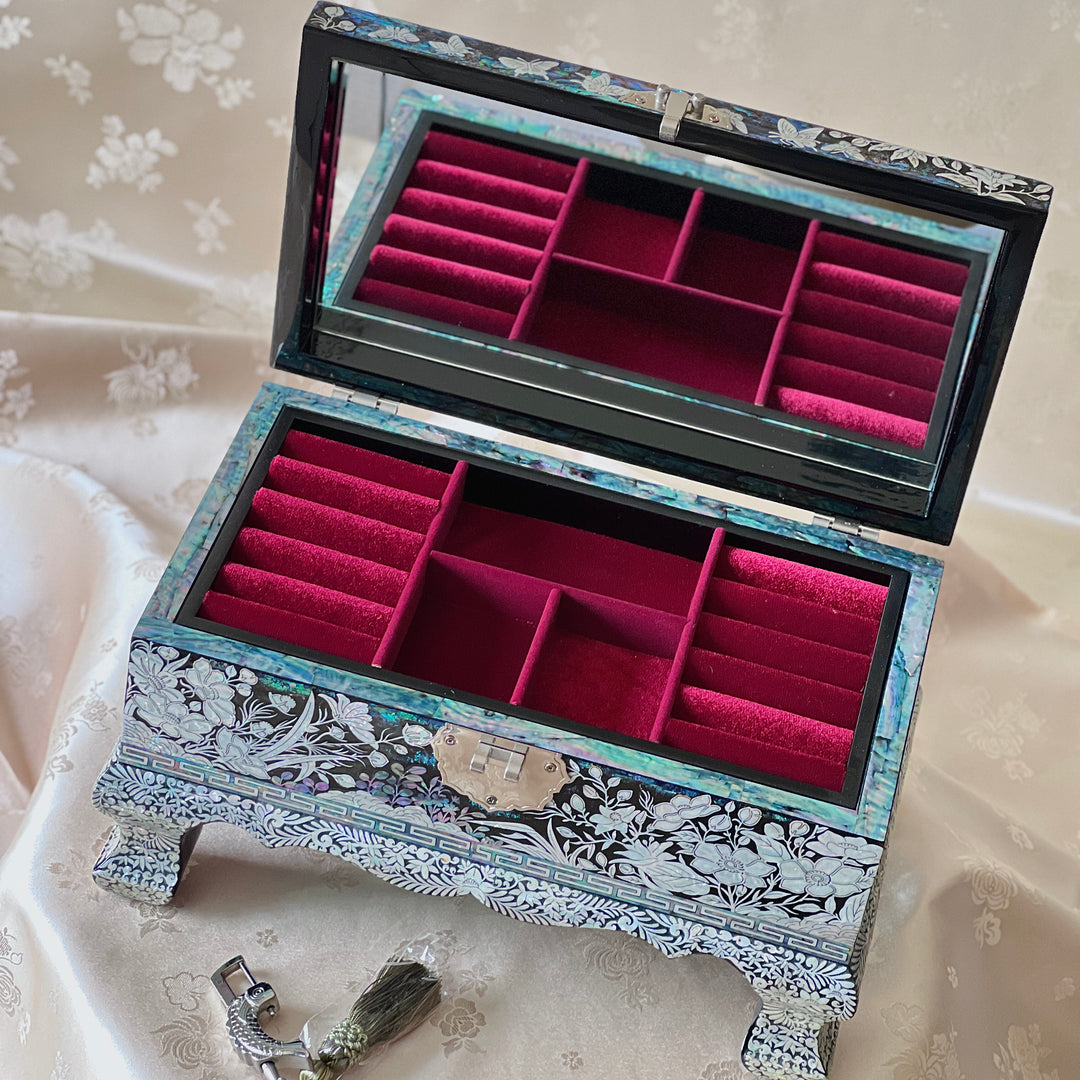 Angled view of an open Korean mother-of-pearl jewelry box with red velvet jewelry compartments