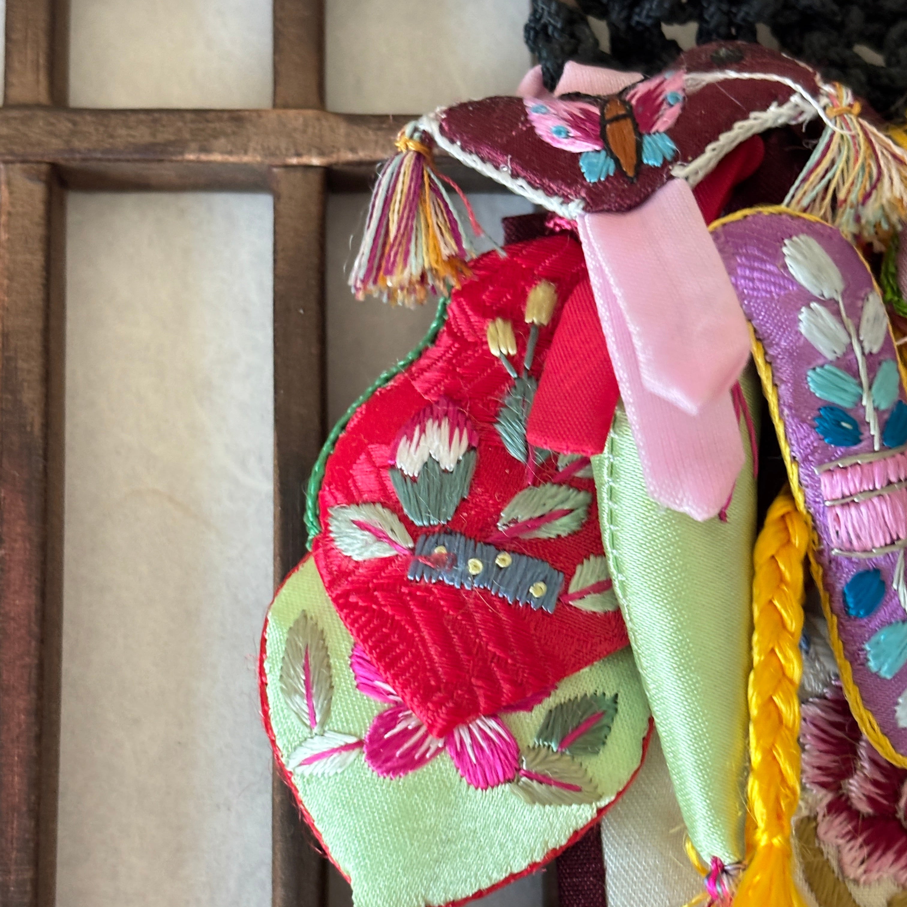 Colorful embroidered fabric with tassels on a wooden surface