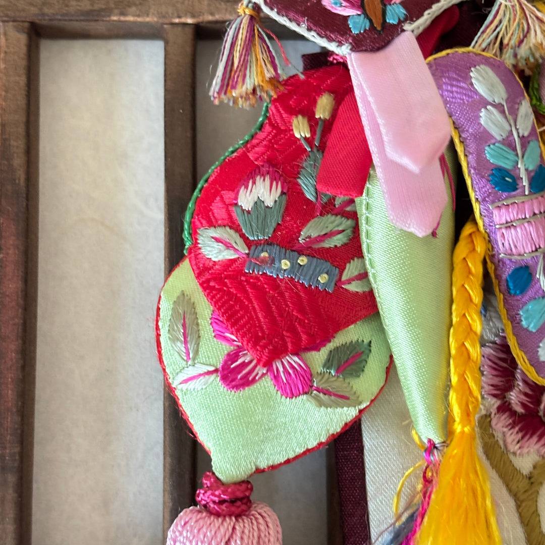 Colorful embroidered fabric with tassels on a wooden surface handmade