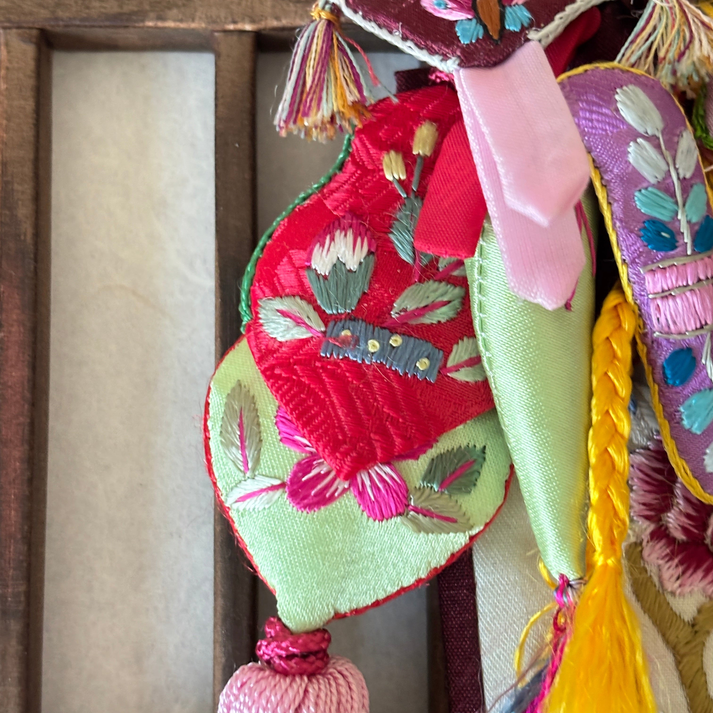 Colorful embroidered fabric with tassels on a wooden surface handmade