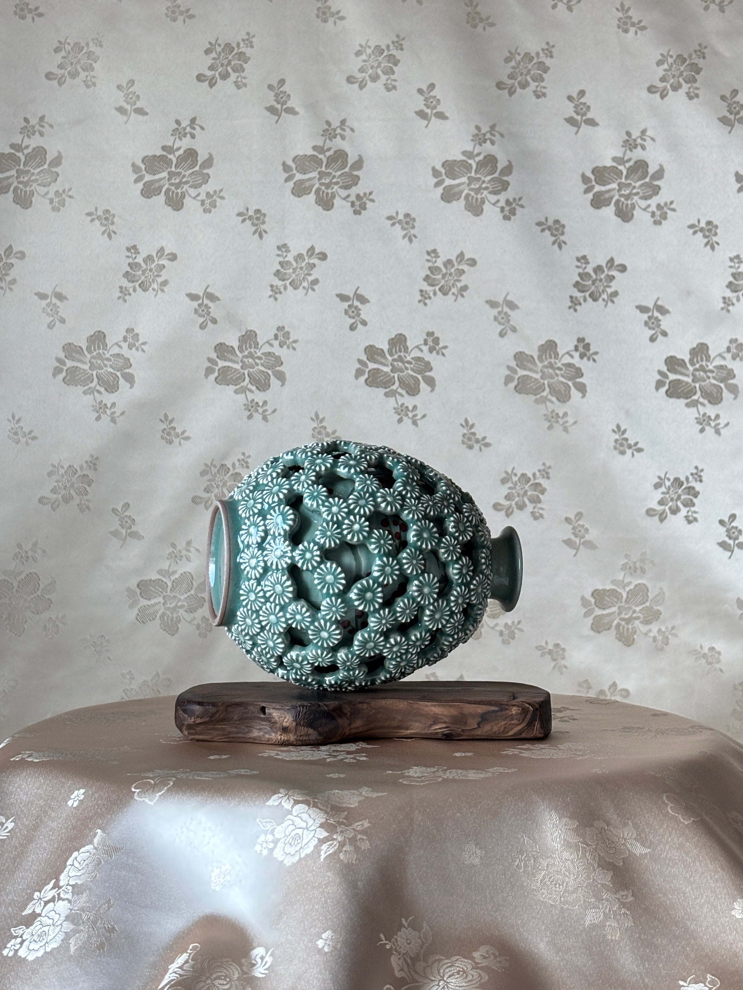 Decorative vase with intricate design on a floral-patterned surface