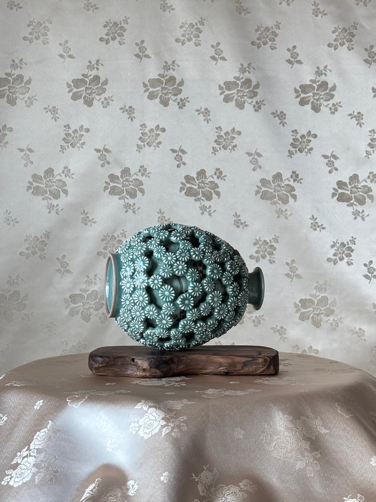 Decorative vase with intricate design on a floral-patterned surface