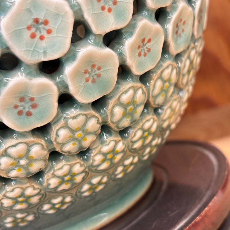 Close-up of a ceramic vase with floral patterns on a wooden surface