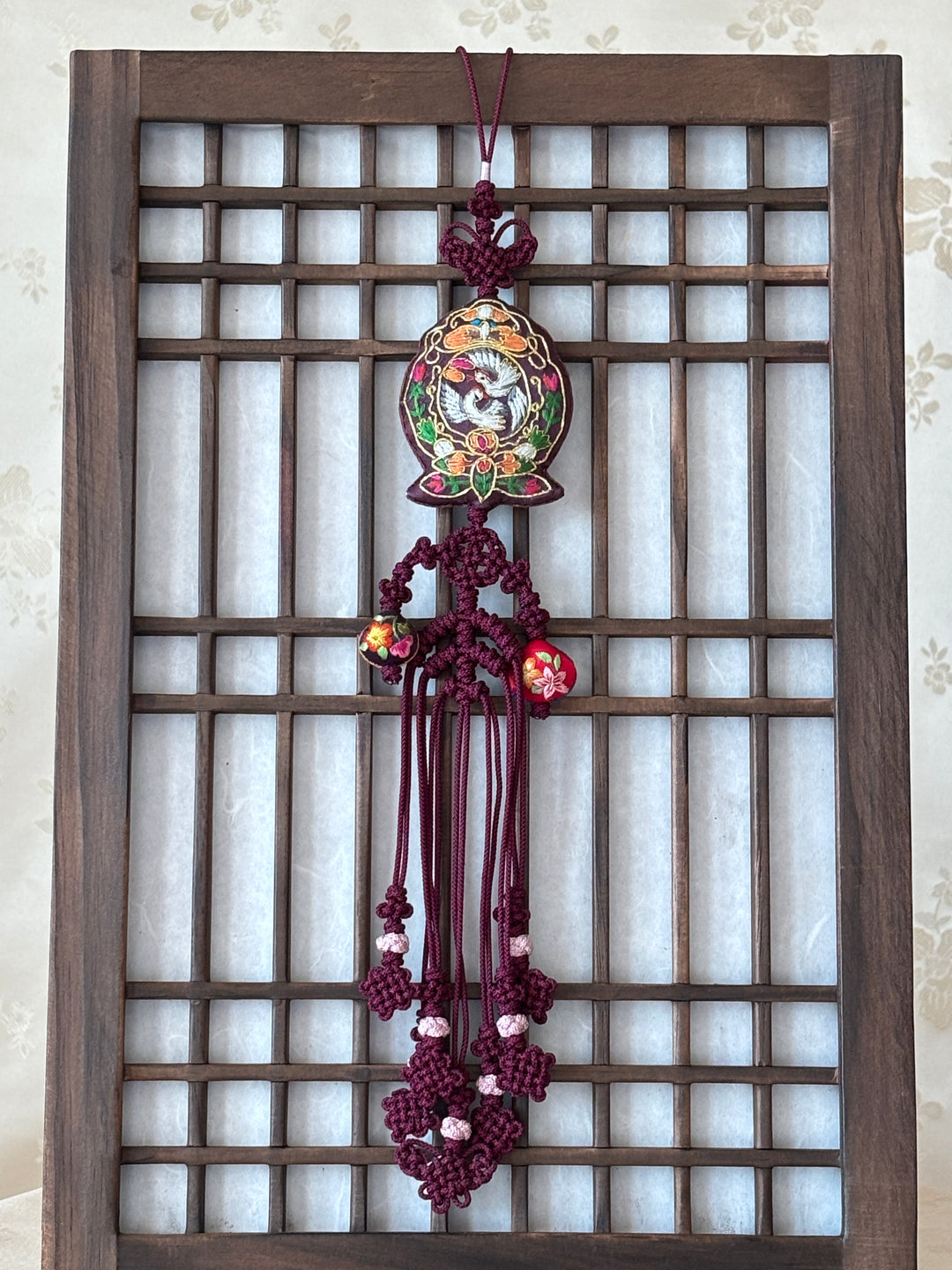 Decorative Korean accessory with floral design on a wooden lattice background