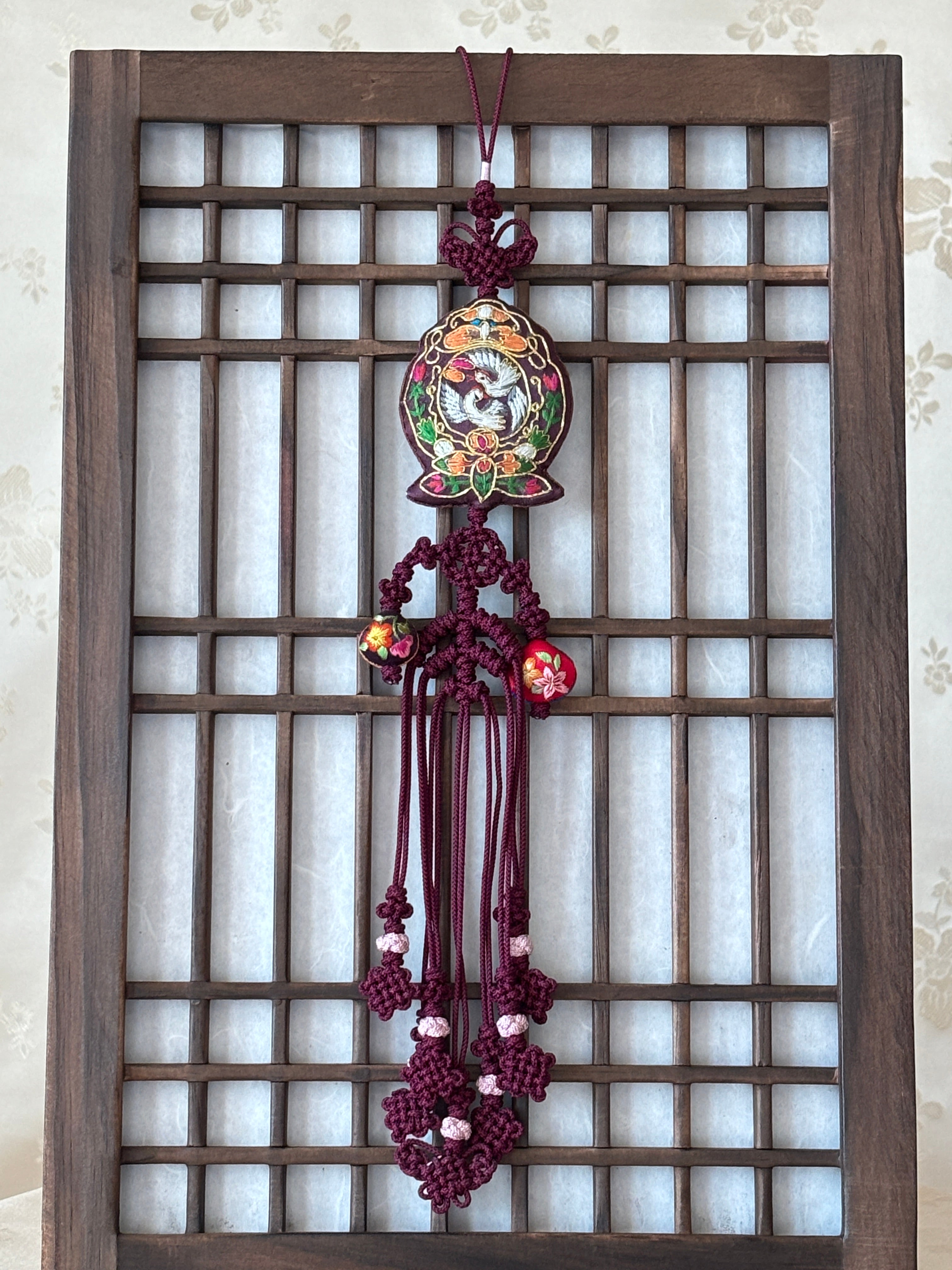 Decorative Korean accessory with floral design on a wooden lattice background