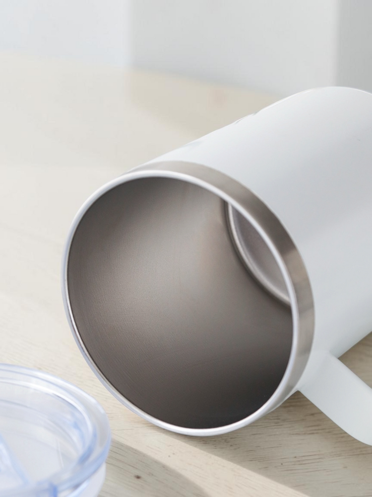 Open top of the stainless steel mug showing the smooth metal interior with the clear lid set beside it