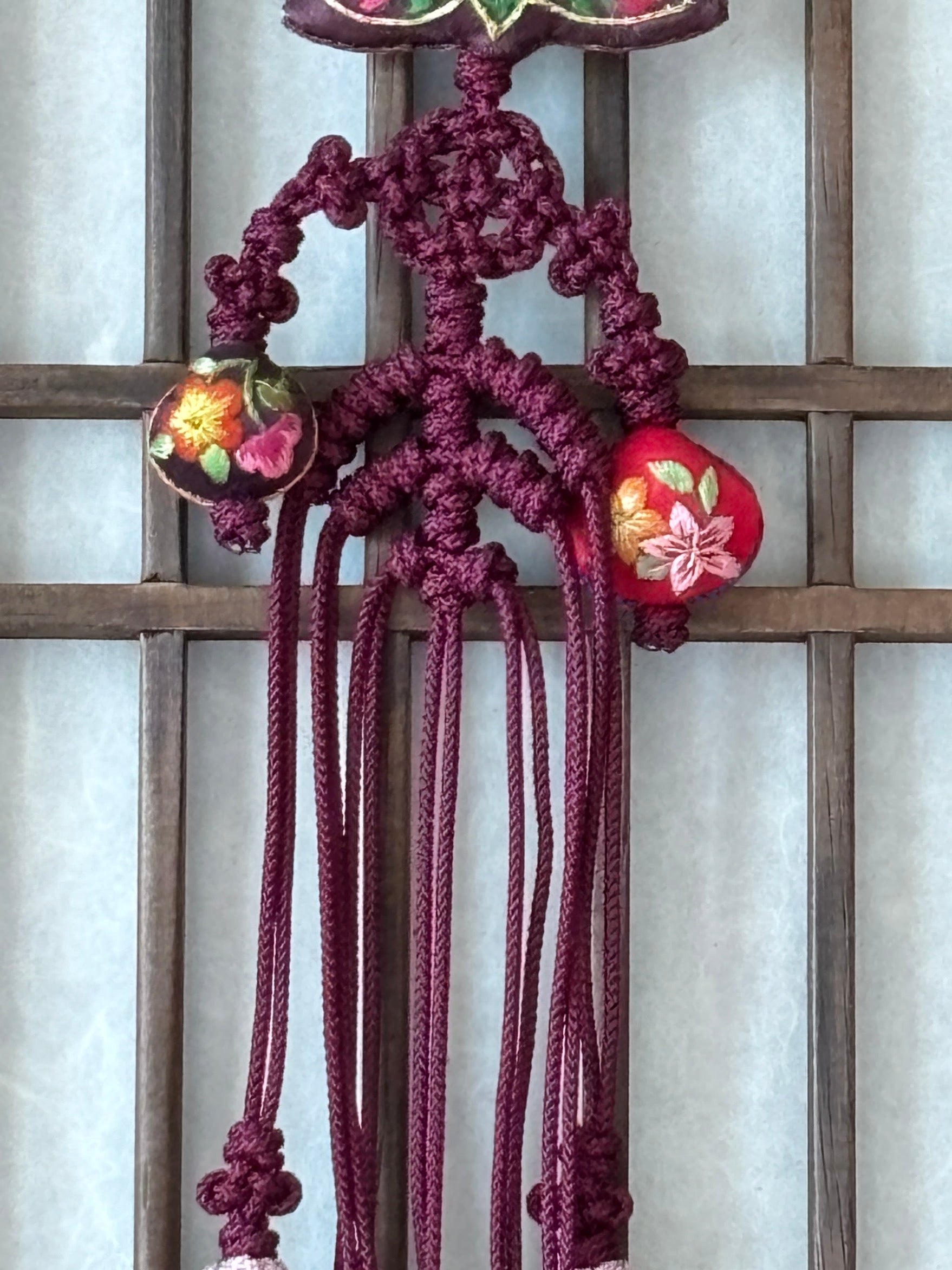 Decorative Korean knot with intricate design on a wooden lattice background