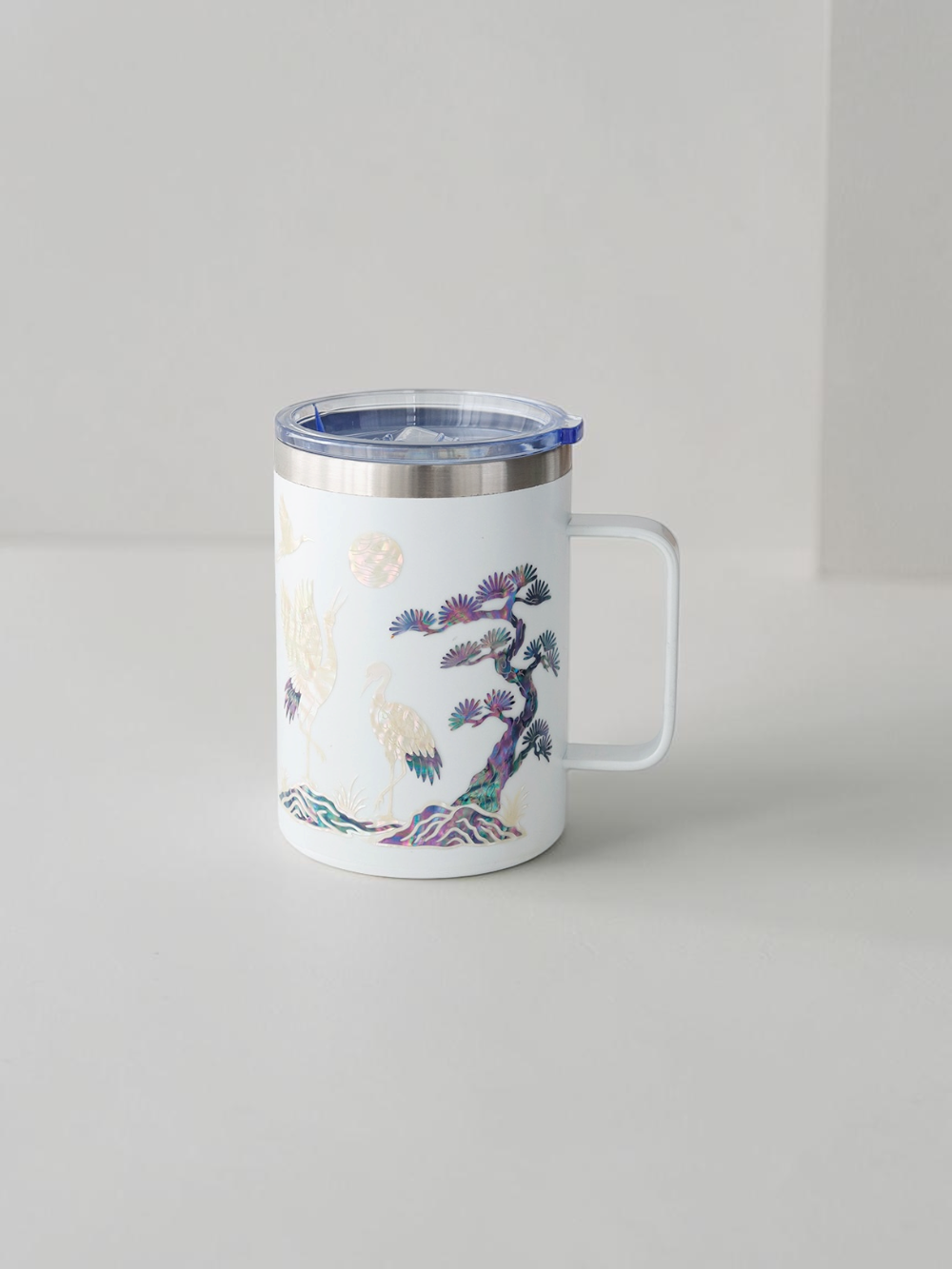 White stainless mug with handle, iridescent mother of pearl cranes and pine branches in blue and violet shell