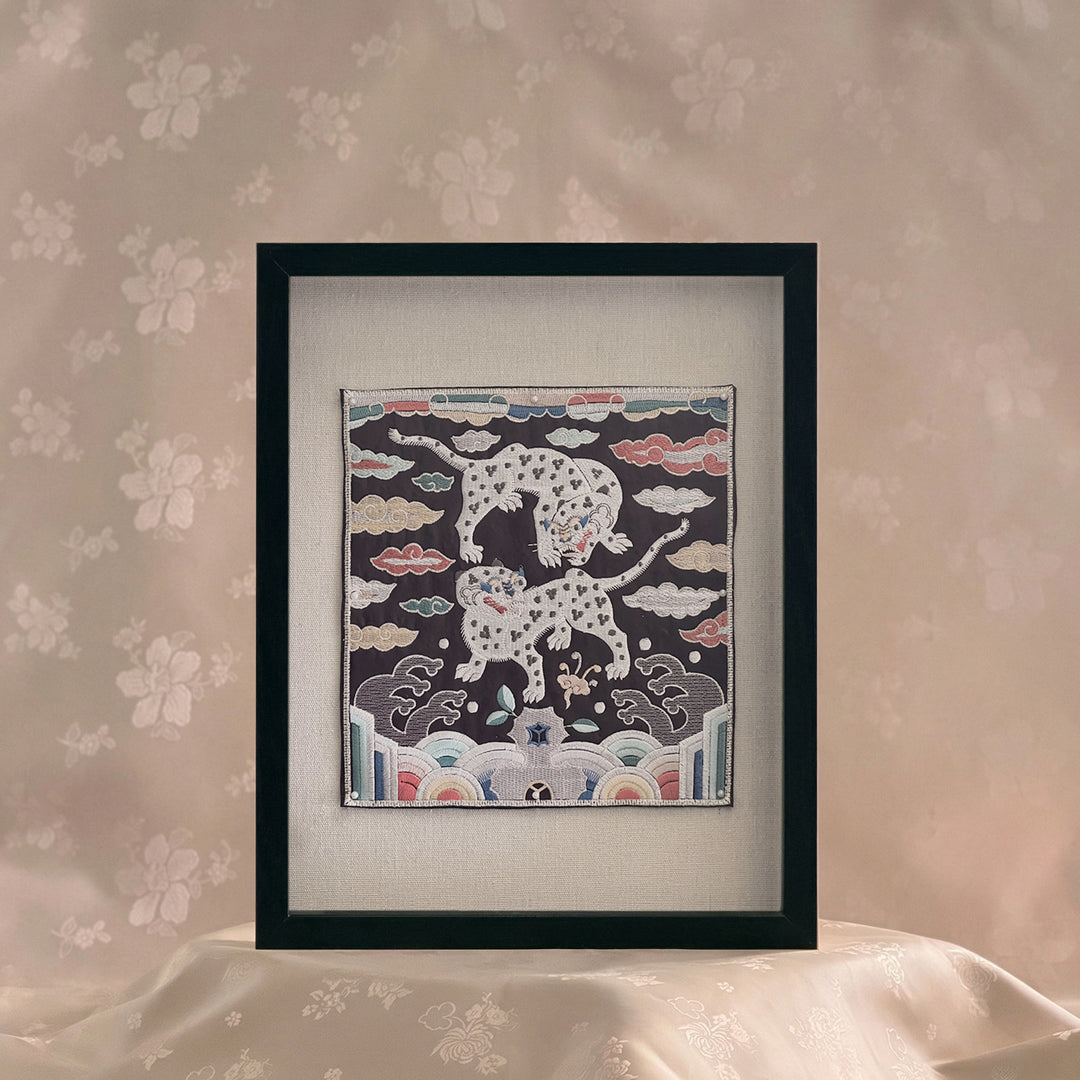 Framed artwork of a snow leopard and cub on a floral wallpaper background