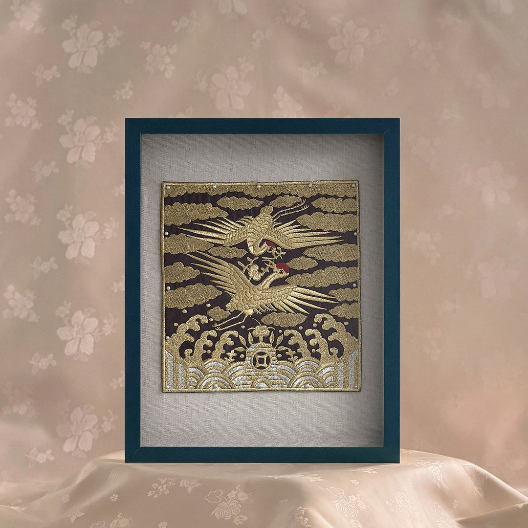 Decorative panel with a gold and white design of a bird on a gray background, framed in blue.
