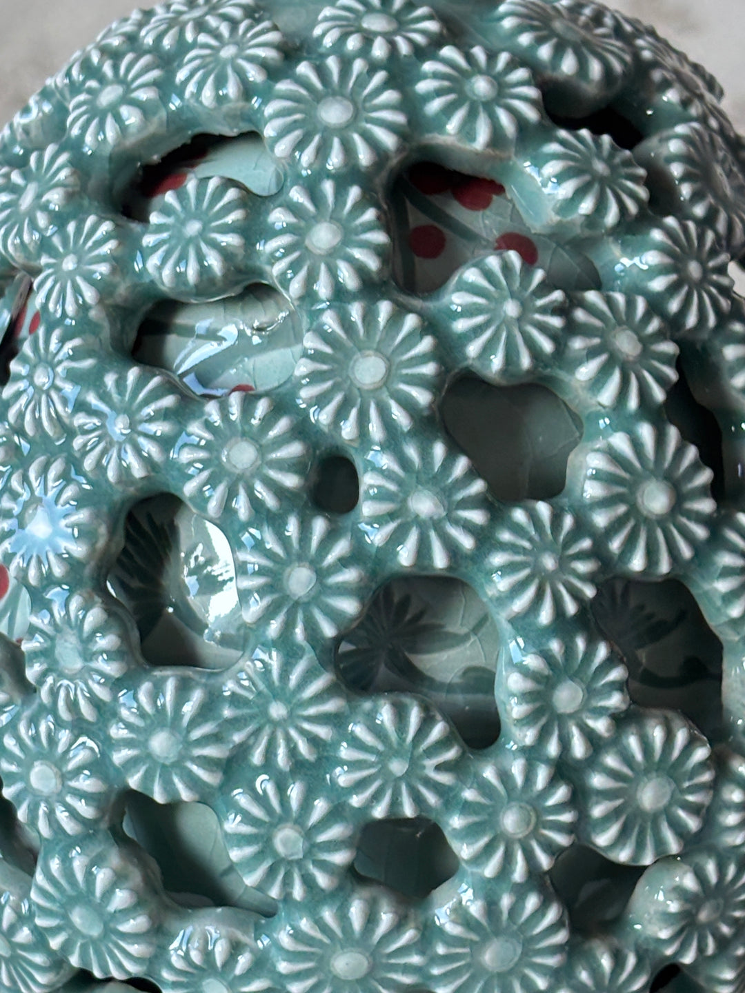 Close-up of a ceramic celadon vase with floral patterns