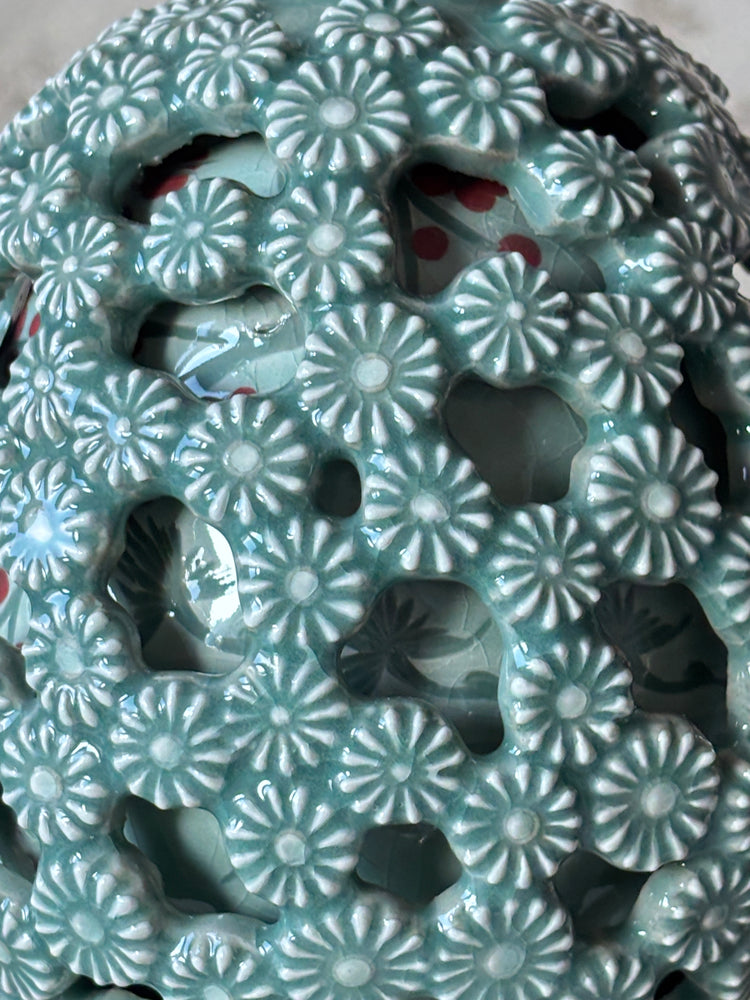 Close-up of a ceramic celadon vase with floral patterns
