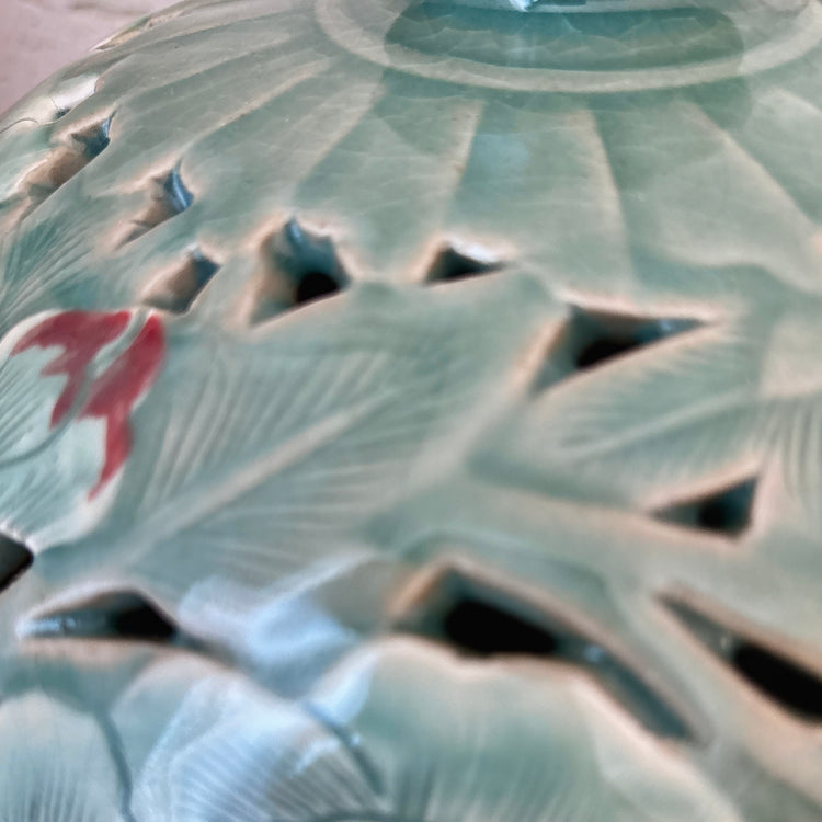 Close-up of a ceramic vase with intricate design and red accents