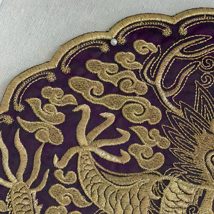 Close-up of gold embroidered design on purple fabric