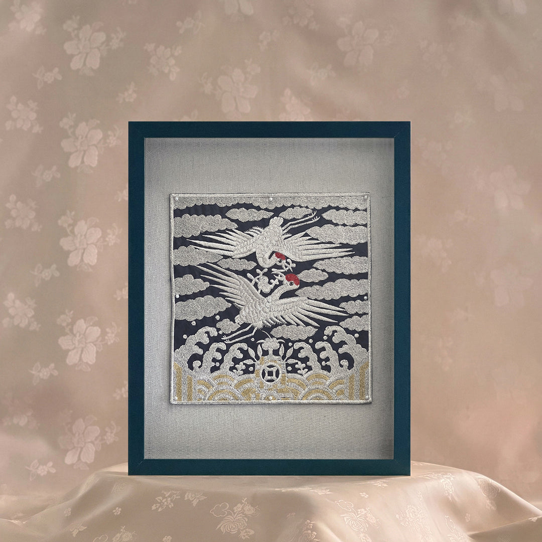 Framed artwork of a crane on a textured wall with floral patterns