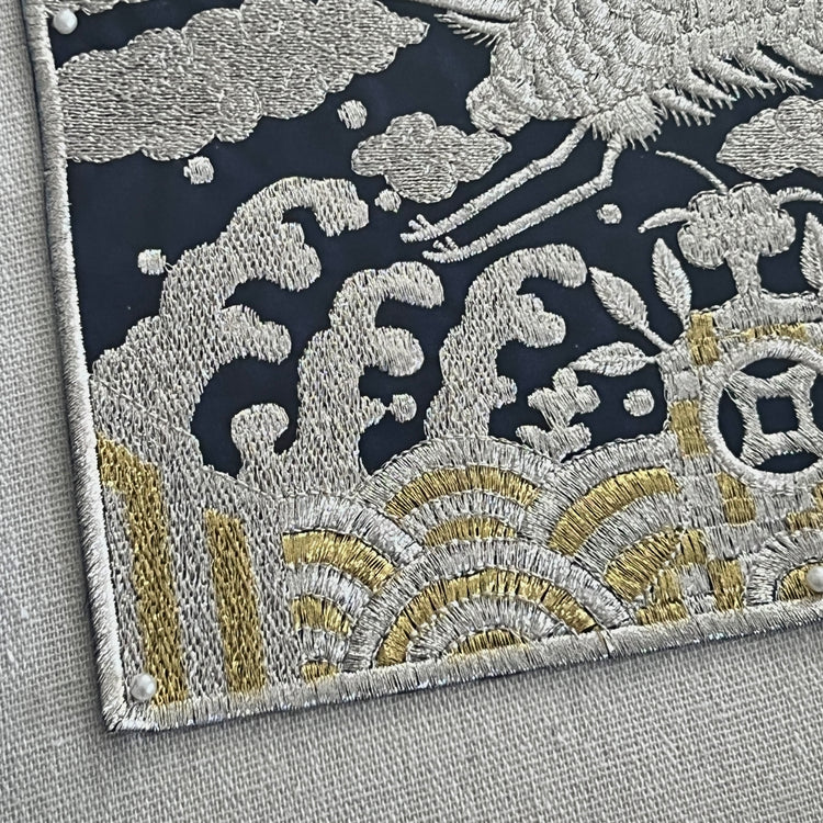 Close-up of embroidered fabric with floral patterns on a gray background