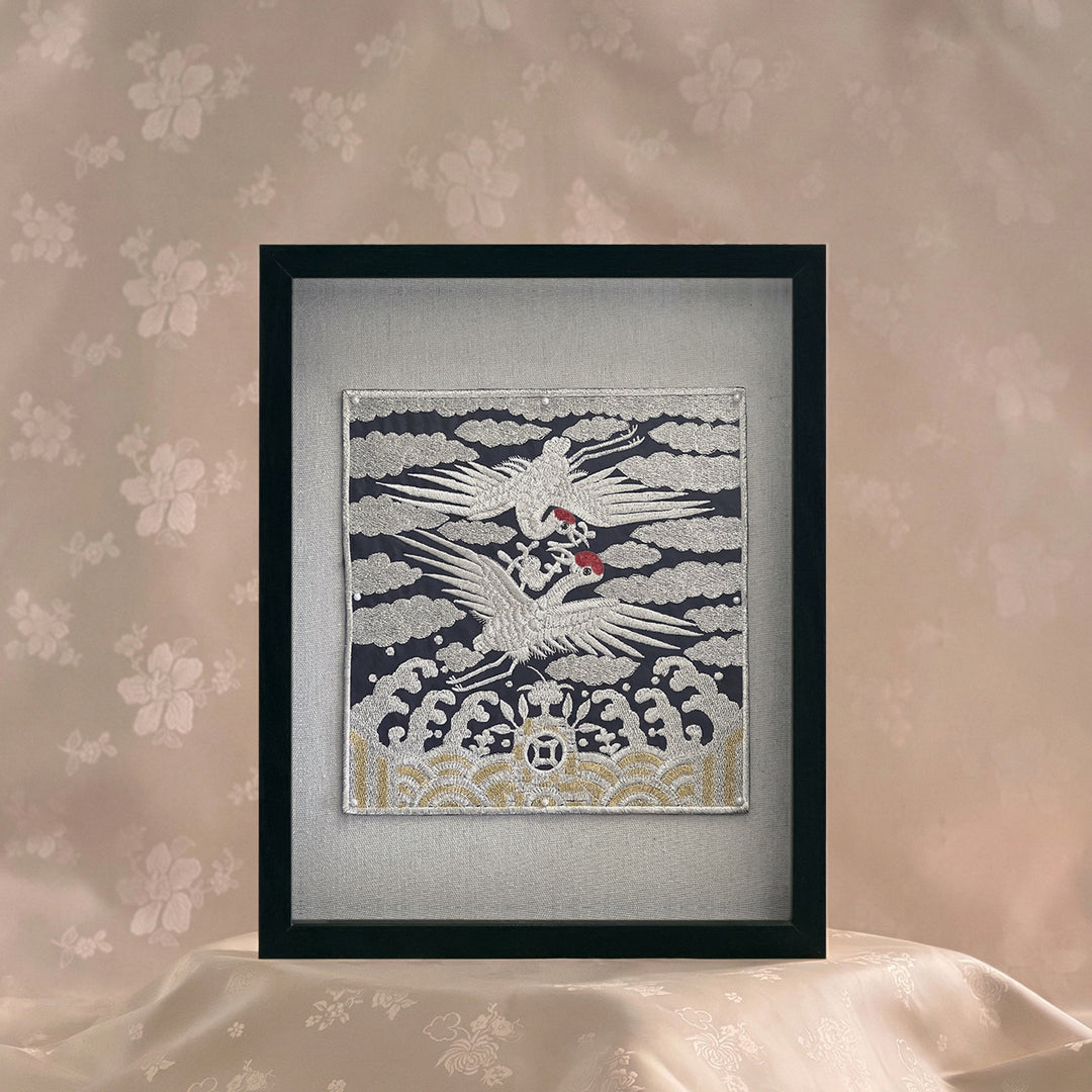 Framed artwork of a crane on a textured wall