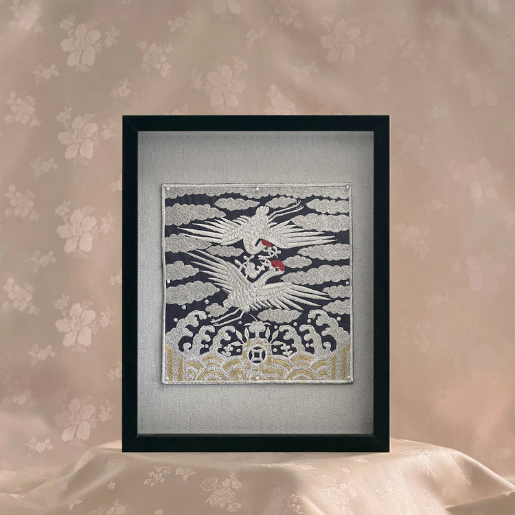 Framed artwork of a crane on a textured wall