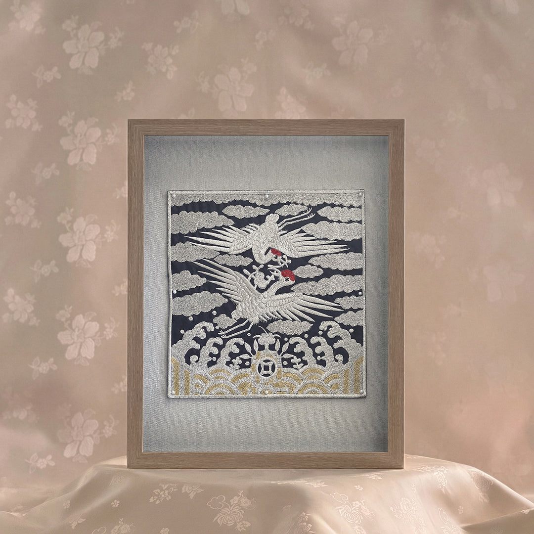 Framed artwork of a crane on a textured wall with floral patterns