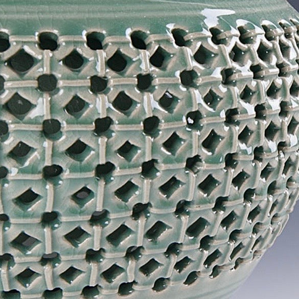 Close-up of a textured ceramic vase with geometric pattern