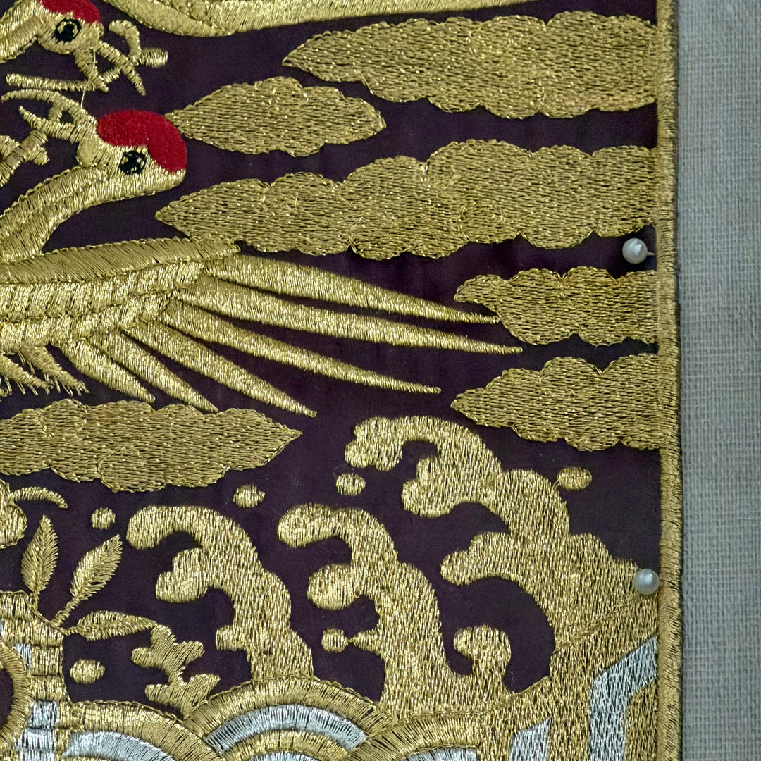Embroidered fabric with gold and black patterns on a dark background