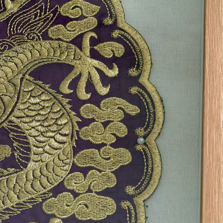 Close-up of gold embroidered dragon design on purple fabric