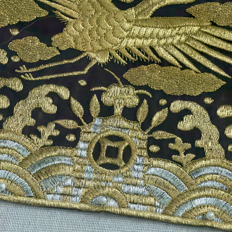 Close-up of intricate gold embroidery on a dark fabric background
